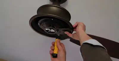 Electrician installing ceiling fan mounting bracket and fixture in Evansville, IN