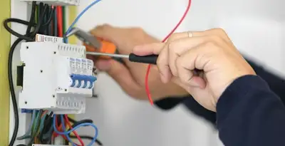 Electrician installing and adjusting circuit breakers in an electrical panel in Evansville, IN