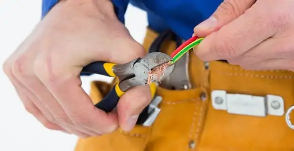licensed electrician securing electrical wiring with professional tools during service work in Evansville, IN