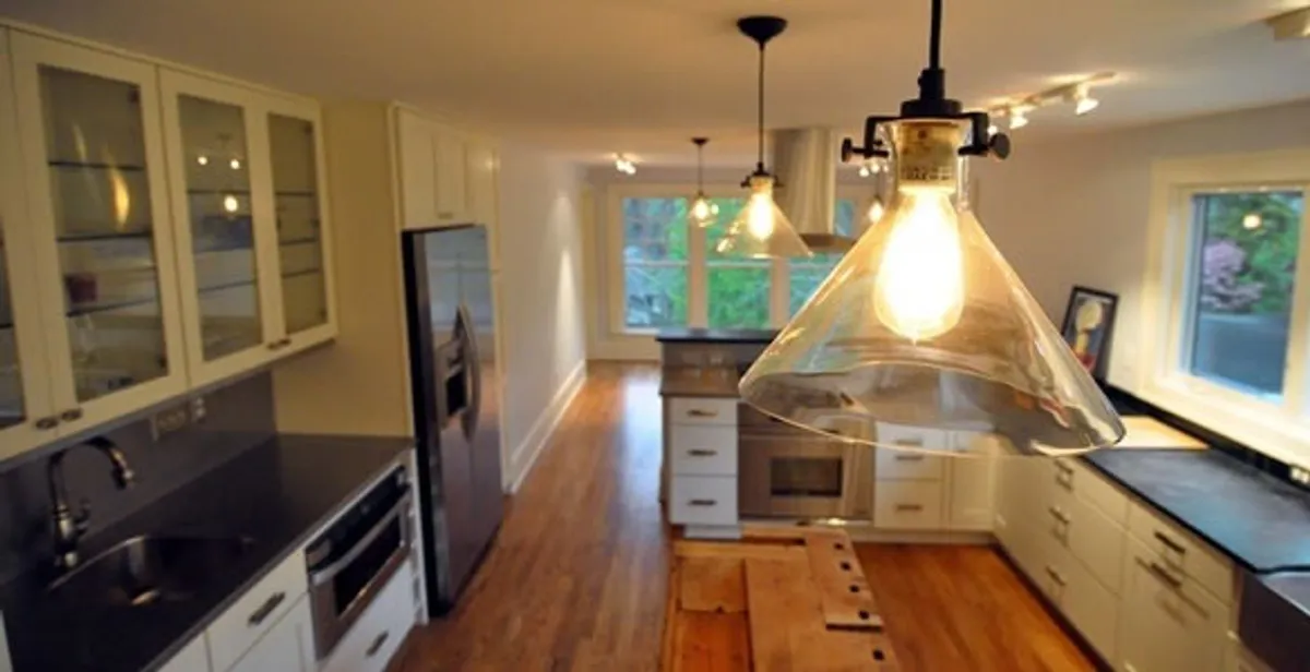 Residential electrician installing modern indoor light fixture in a home in Evansville, IN