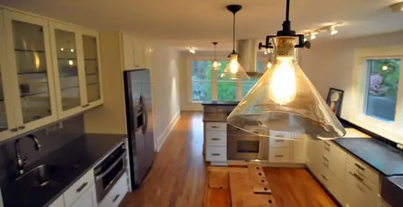 Residential electrician installing modern indoor light fixture in a home in Evansville, IN
