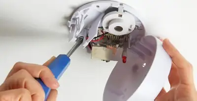 Certified technician wiring smoke detector during installation in Evansville, IN